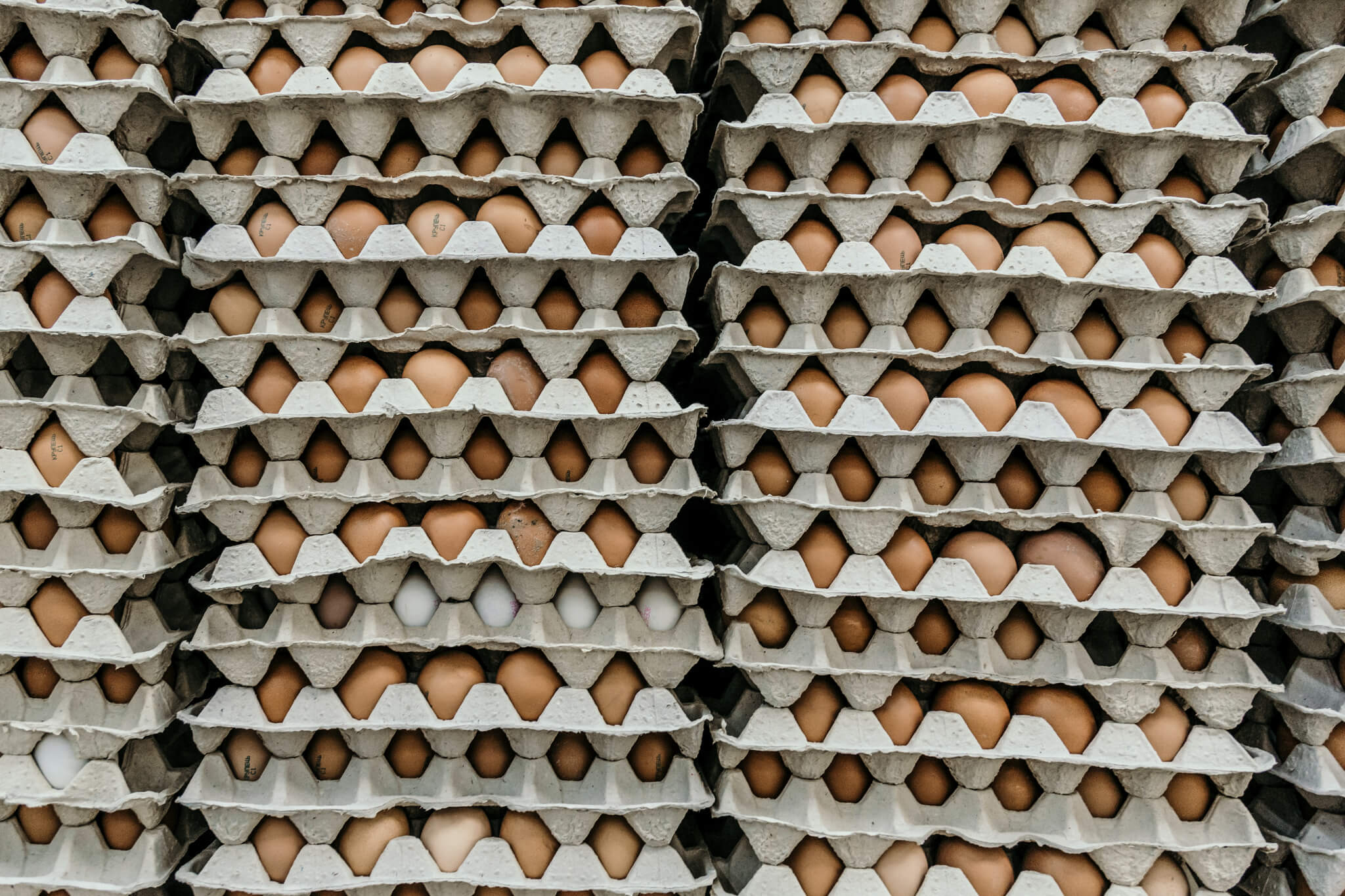 Stacks of brown chicken eggs in crates.