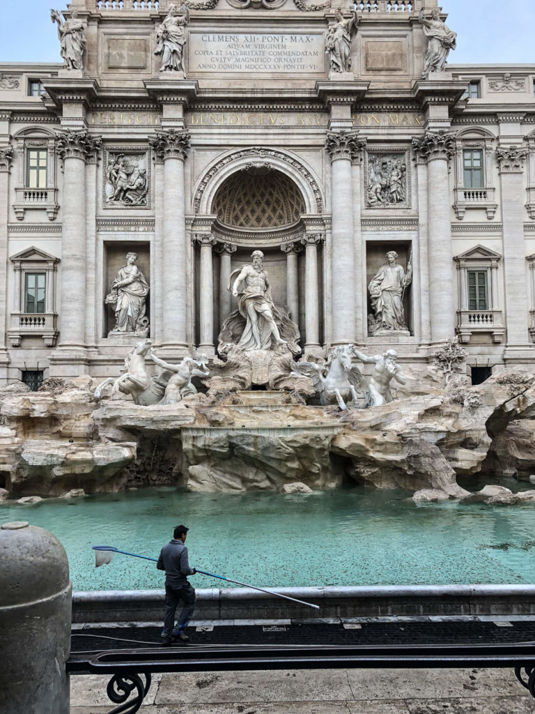 Trevi Fountain with city employee collecting coins. 